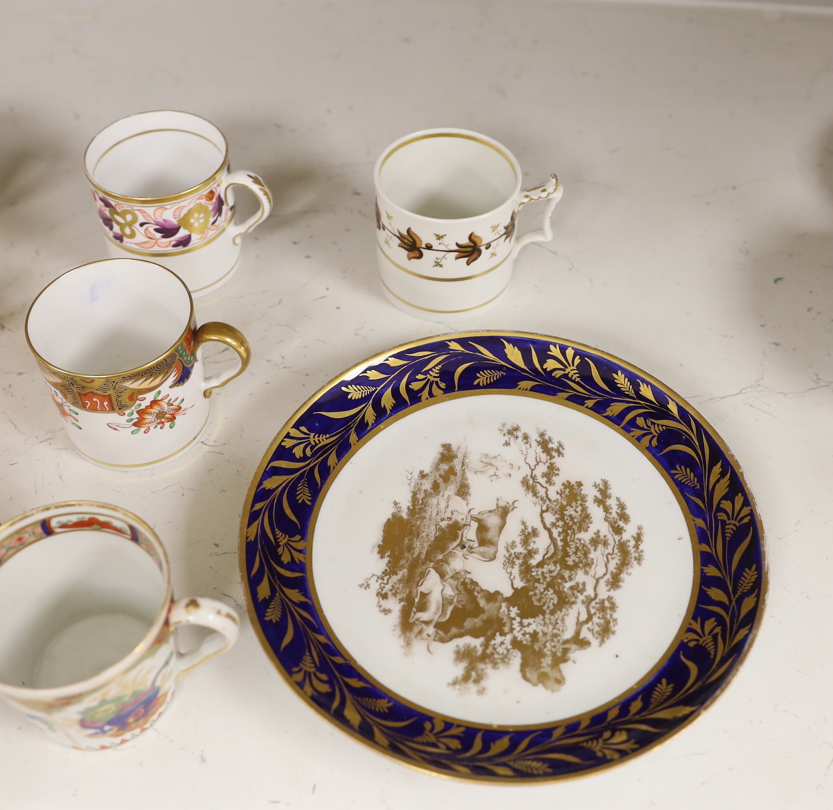English porcelain coffee cans including Worcester, Spode, Wolfe Mason, Derby and Chamberlain, two New hall cans and saucers and a New hall Warburton’s Patent saucer dish, the largest 20cm in diameter